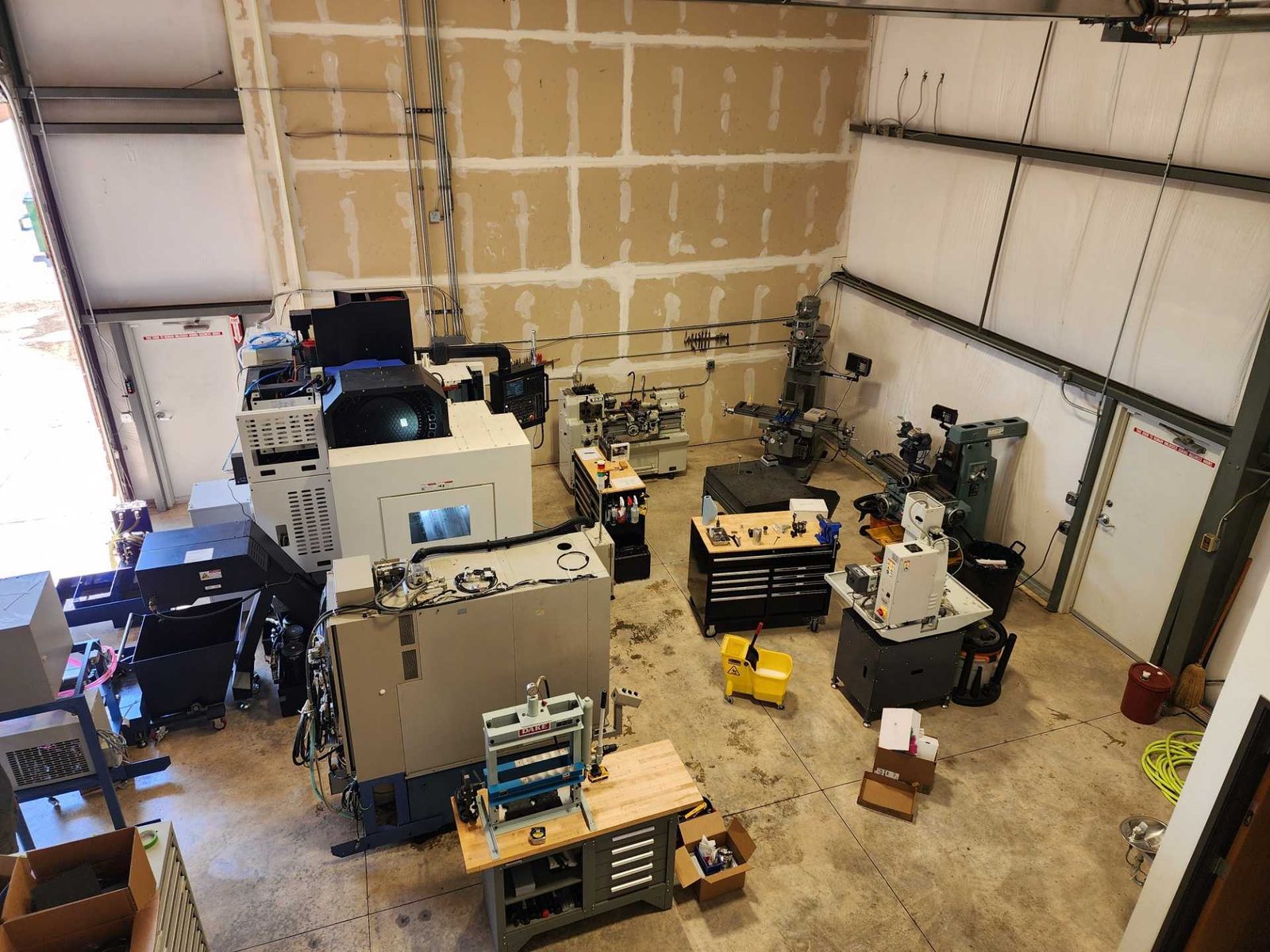 Machine shop with CNC mills, a lathe, manual mills and work benches